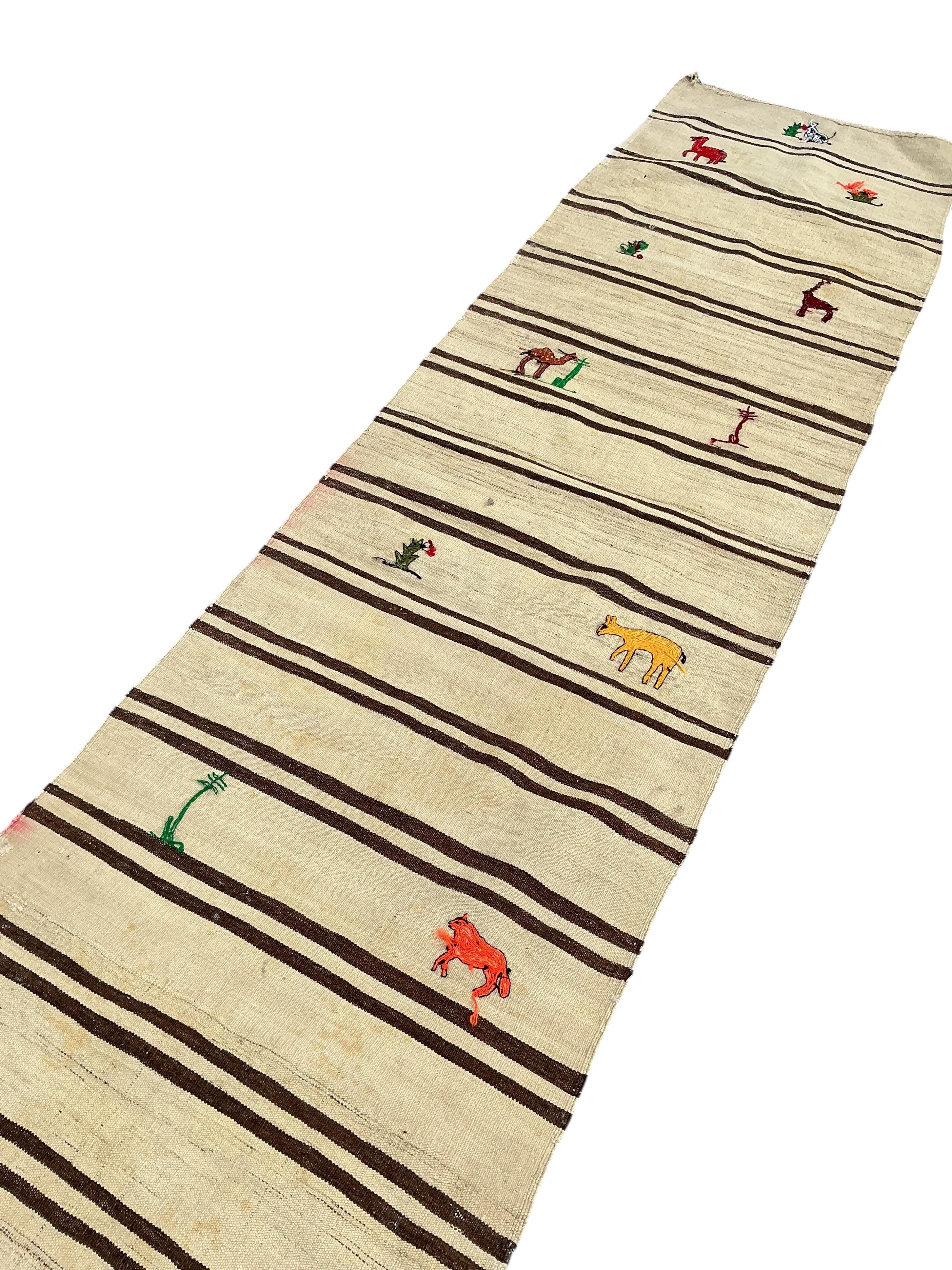 A Turkish kilim flat weave runner woven with animals and flowers, 370 x 82cm